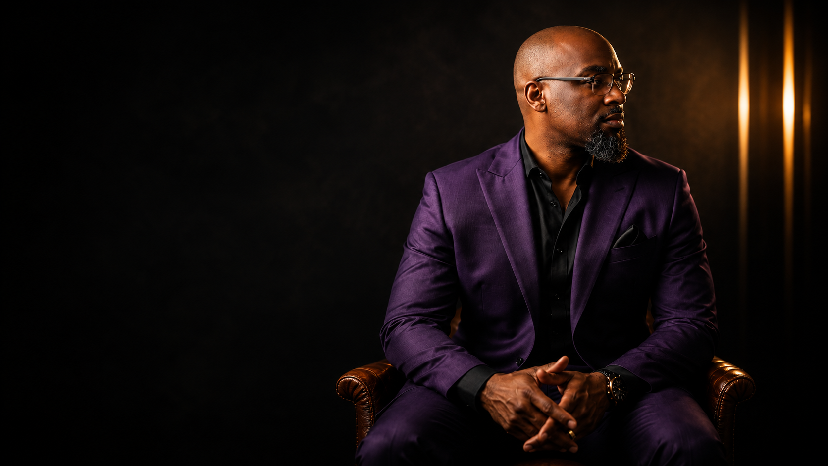 C. Christopher Scott, creative director, seated in a purple suit